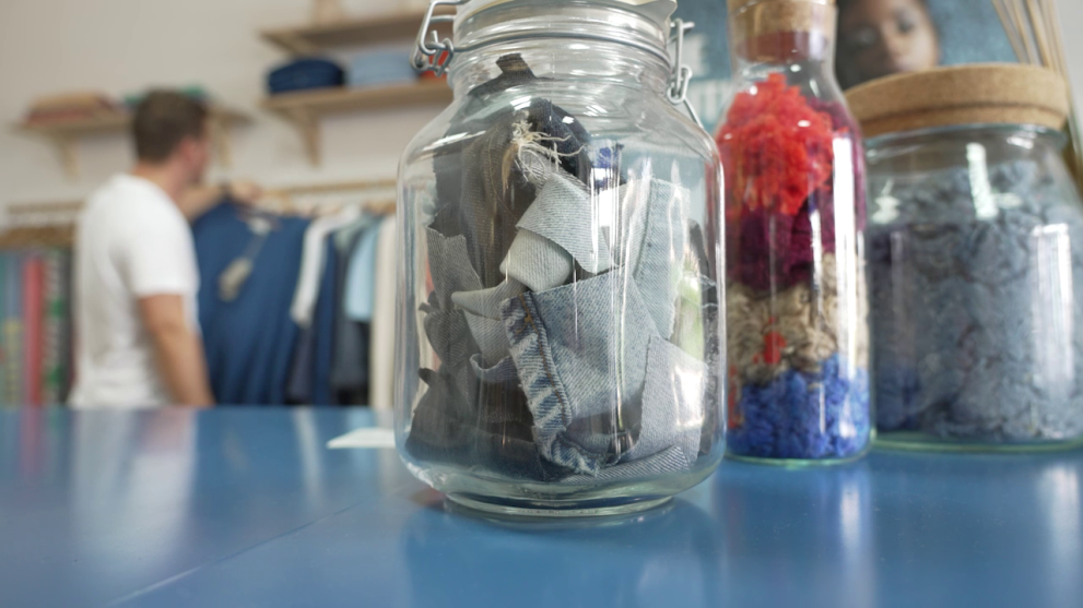 Jars on tables containing textiles.